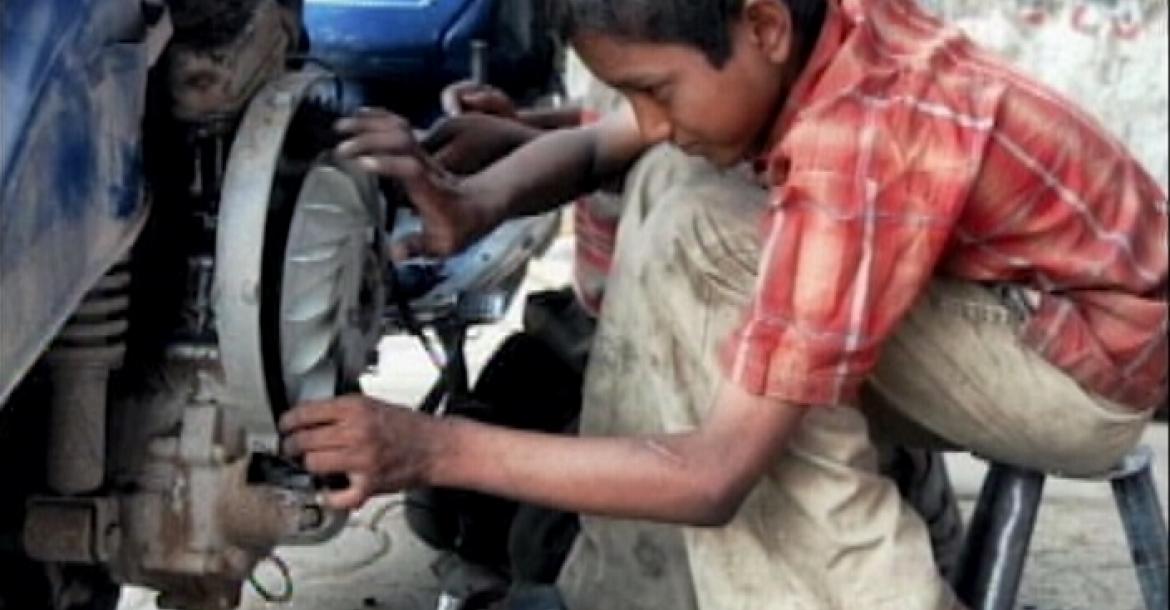 Young Boy working in a Mechanic Shop